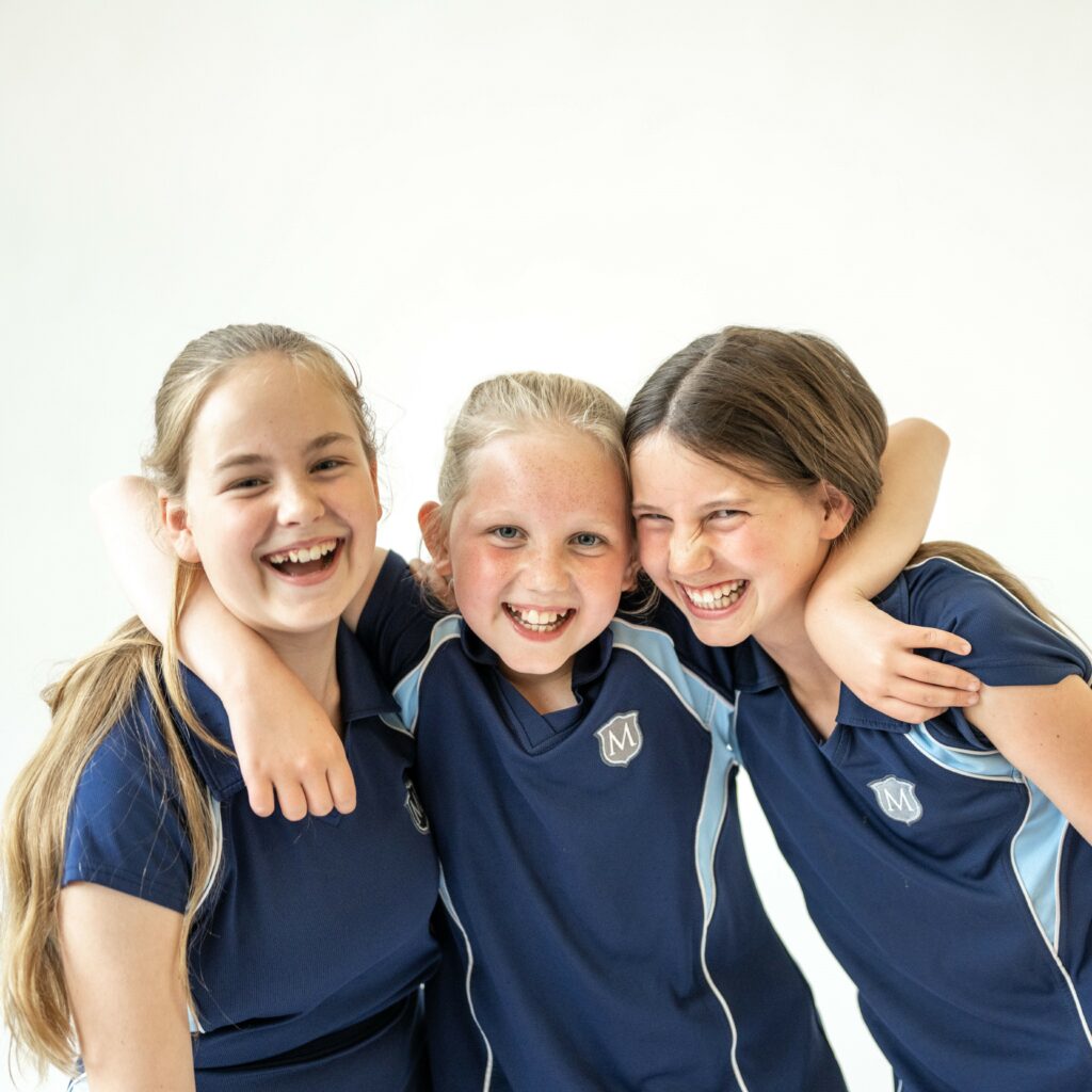 Three girls hugging and smiling