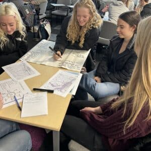 Girls around a table looking at paperwork
