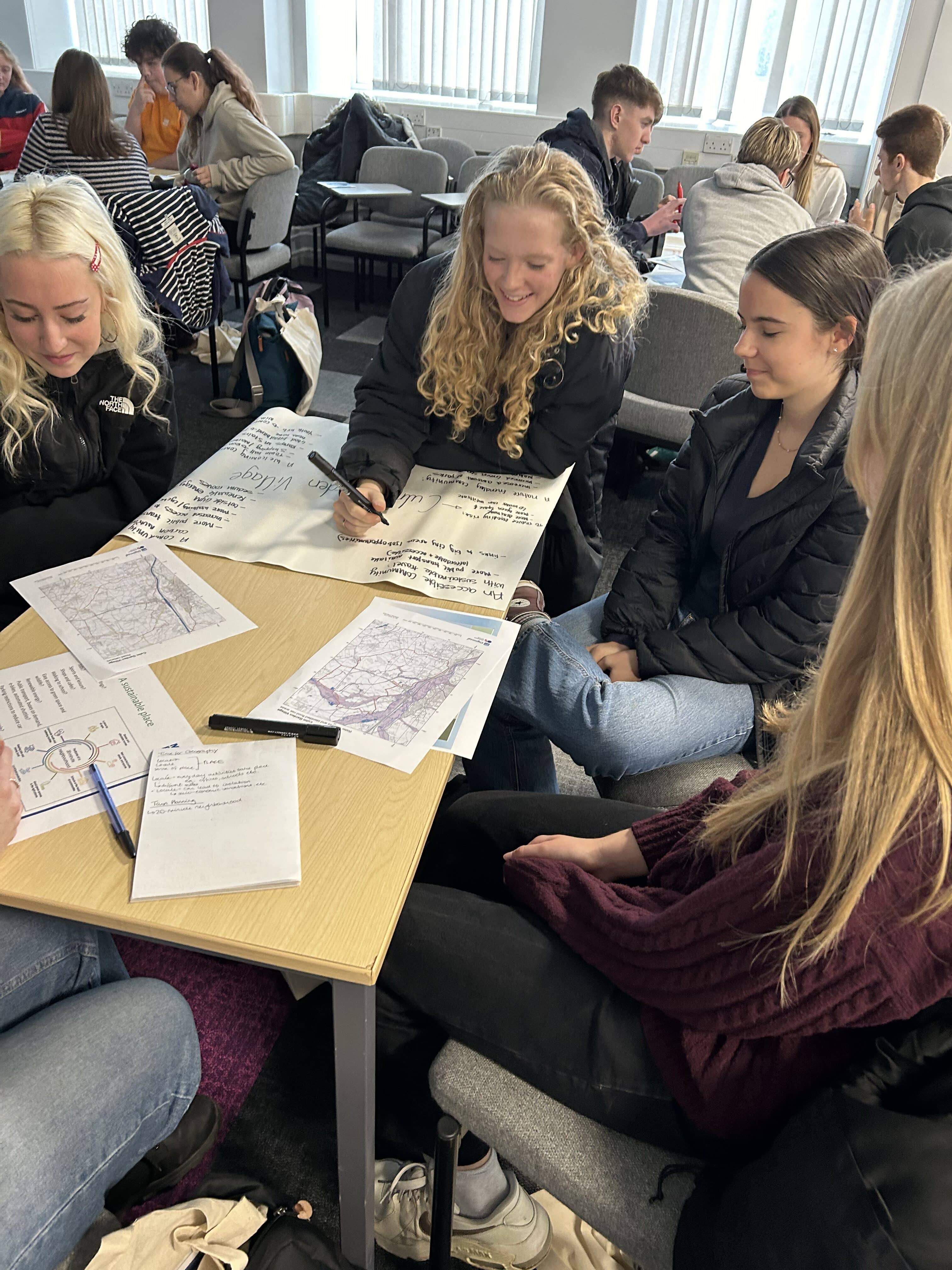 Girls around a table looking at paperwork