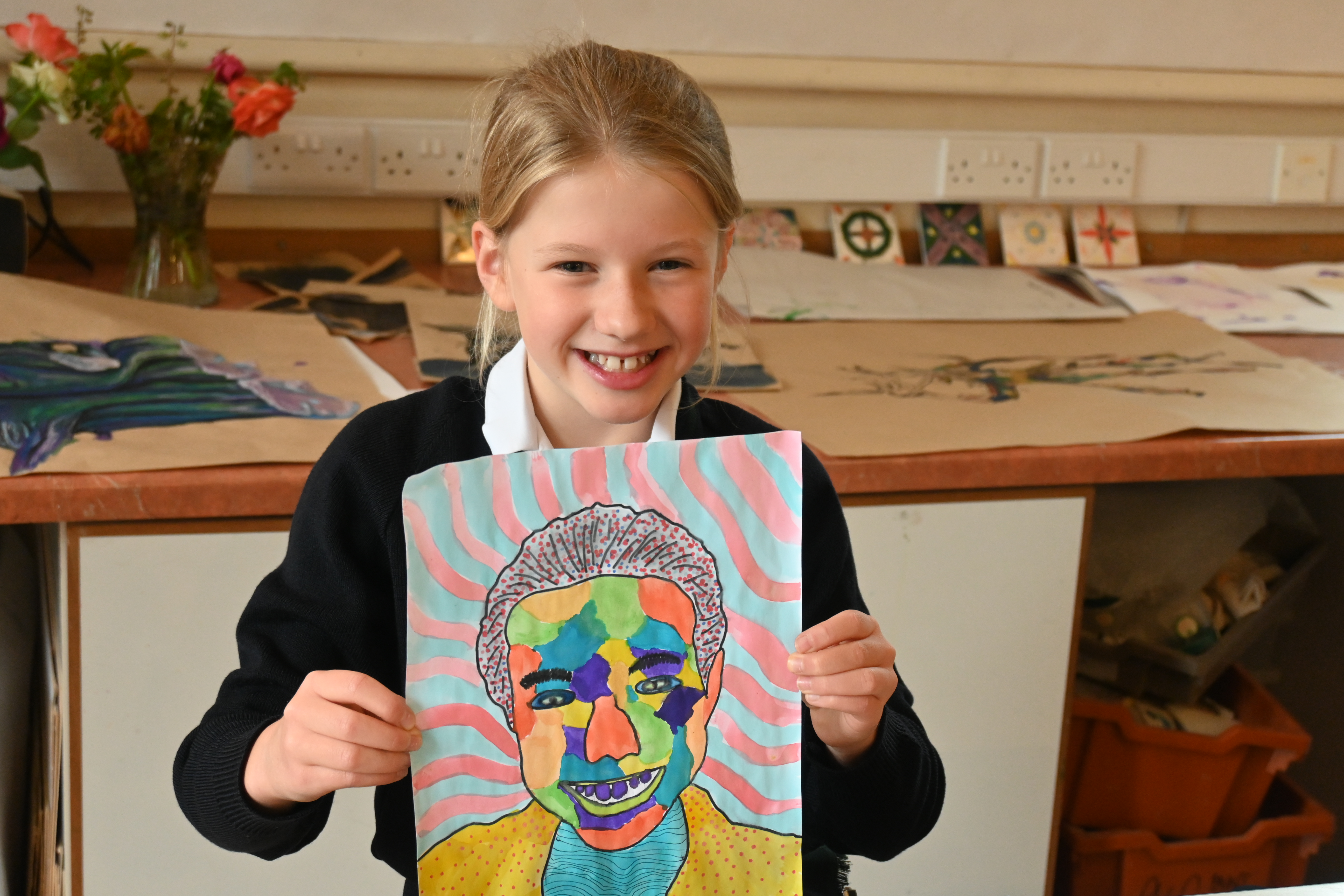 Girl smiling holding up pop art portrait