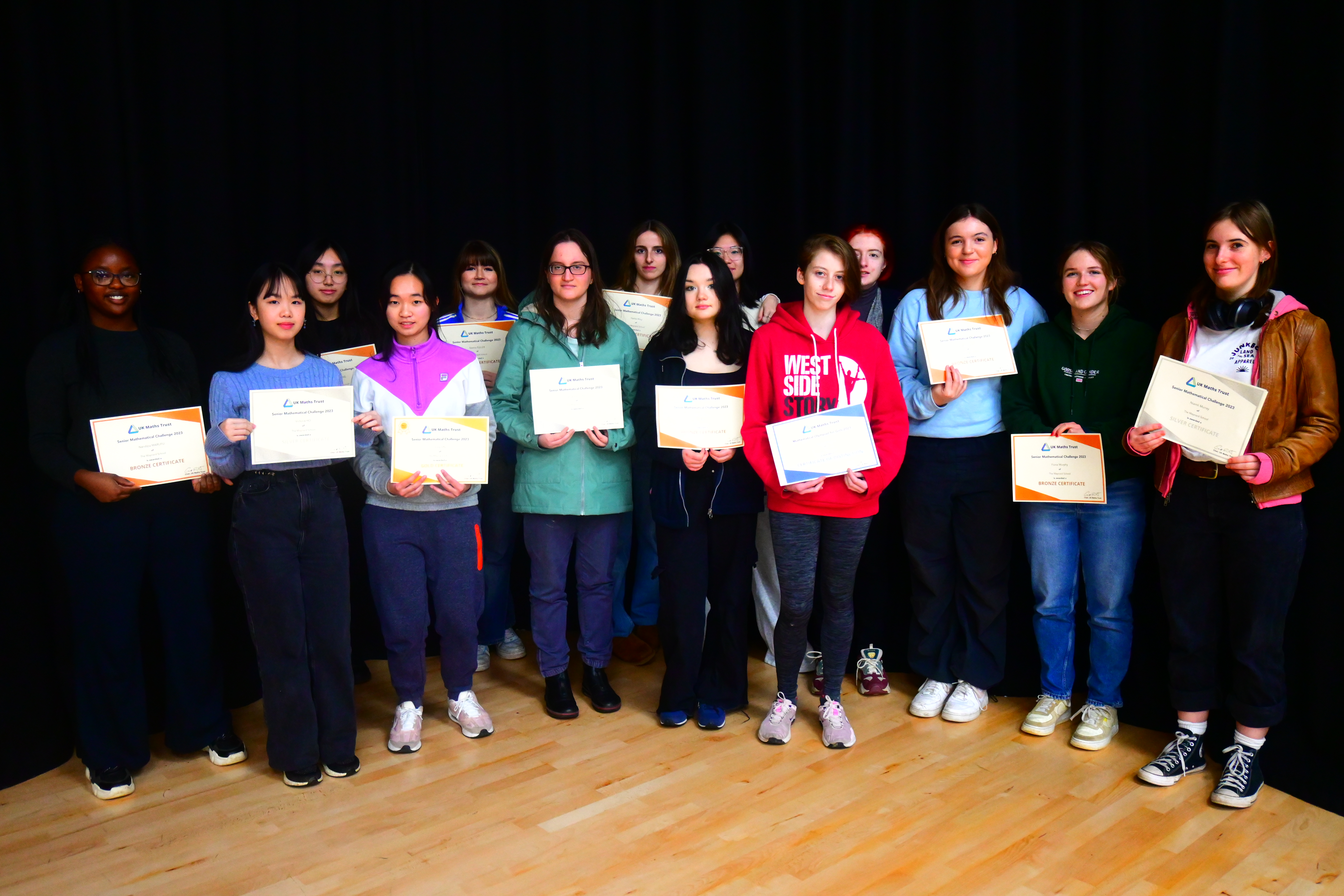 Sixth Form girls holding up certificates