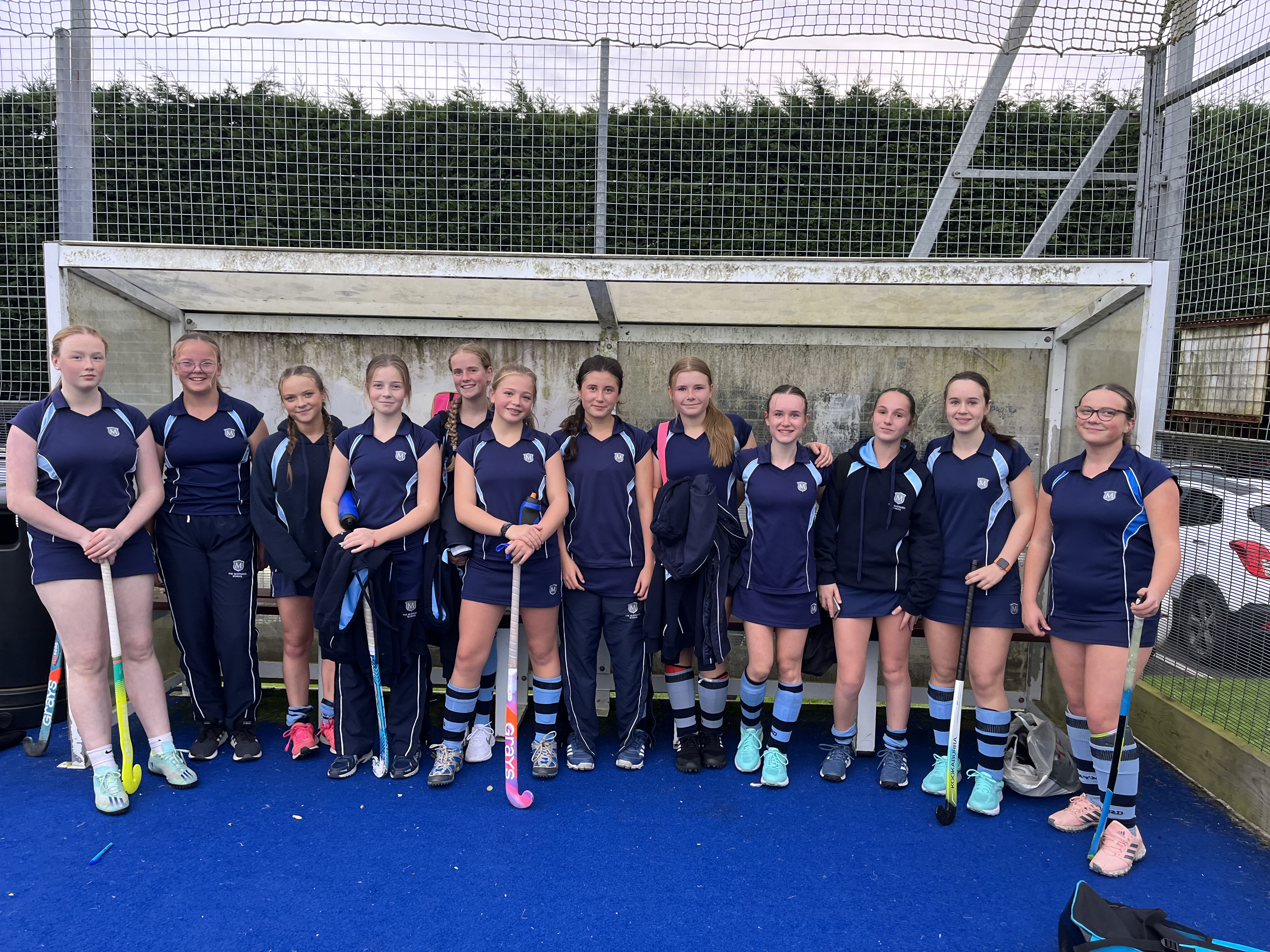 Girls holding hockey sticks