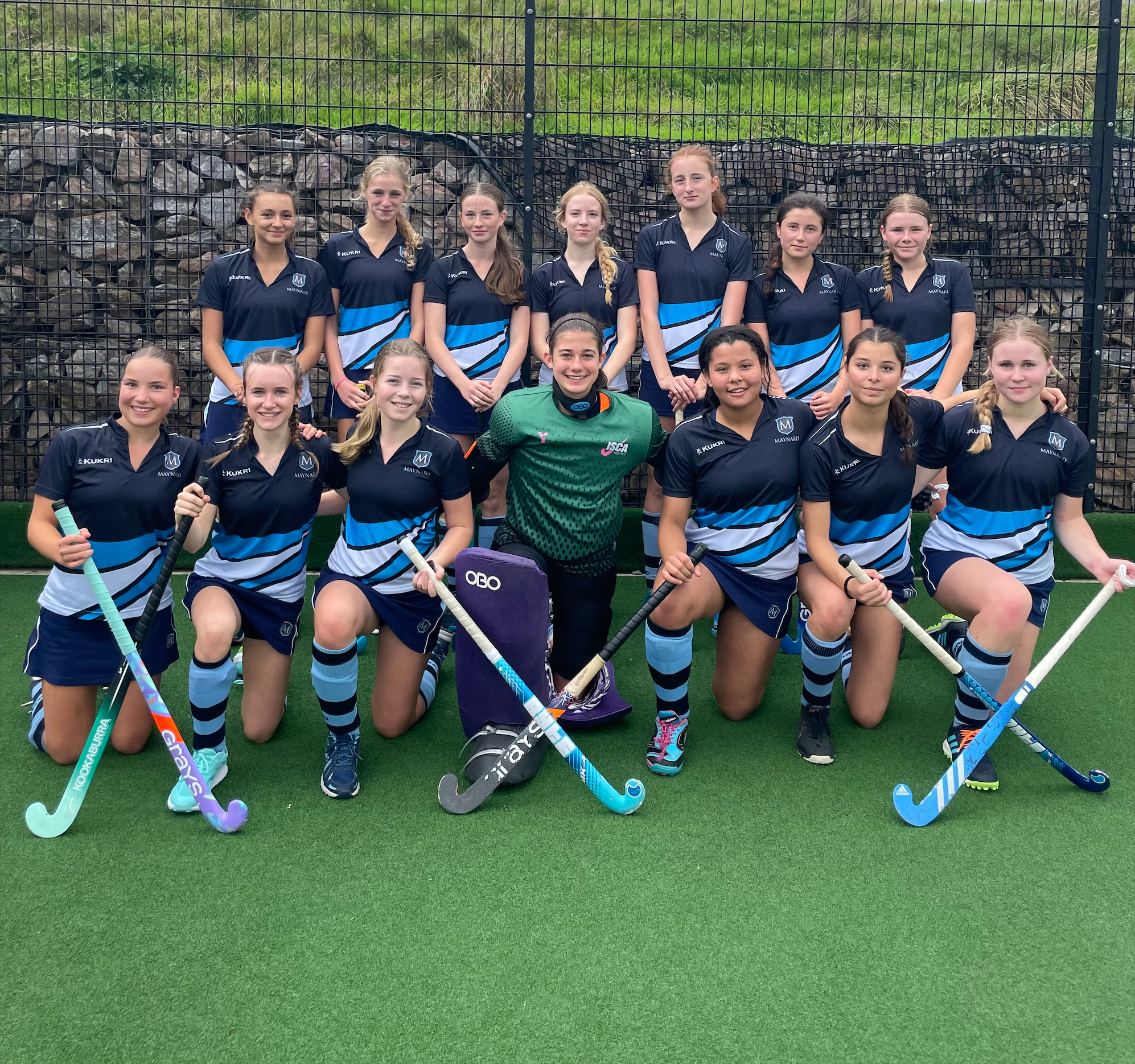 Girls smiling with hockey sticks