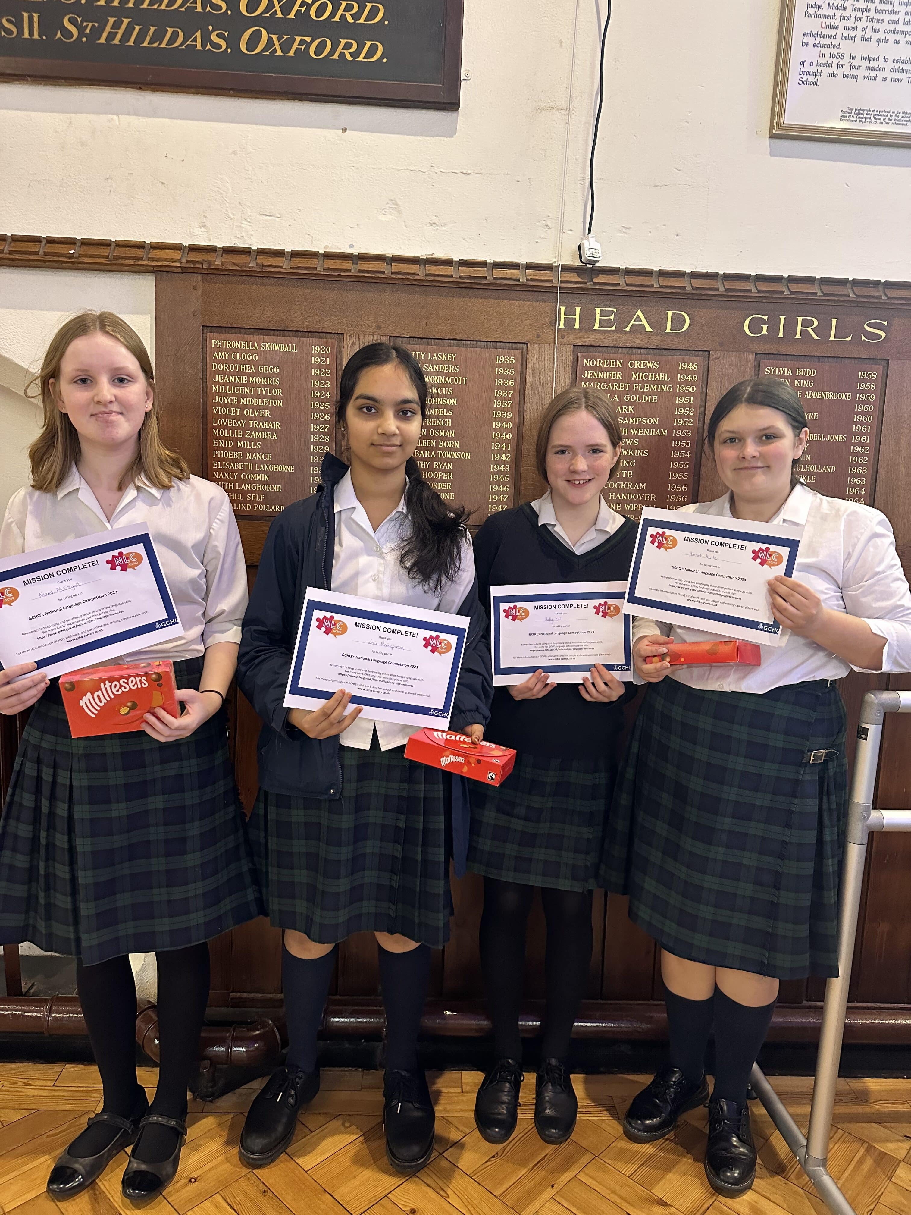 Fours girls smiling holding up certificates