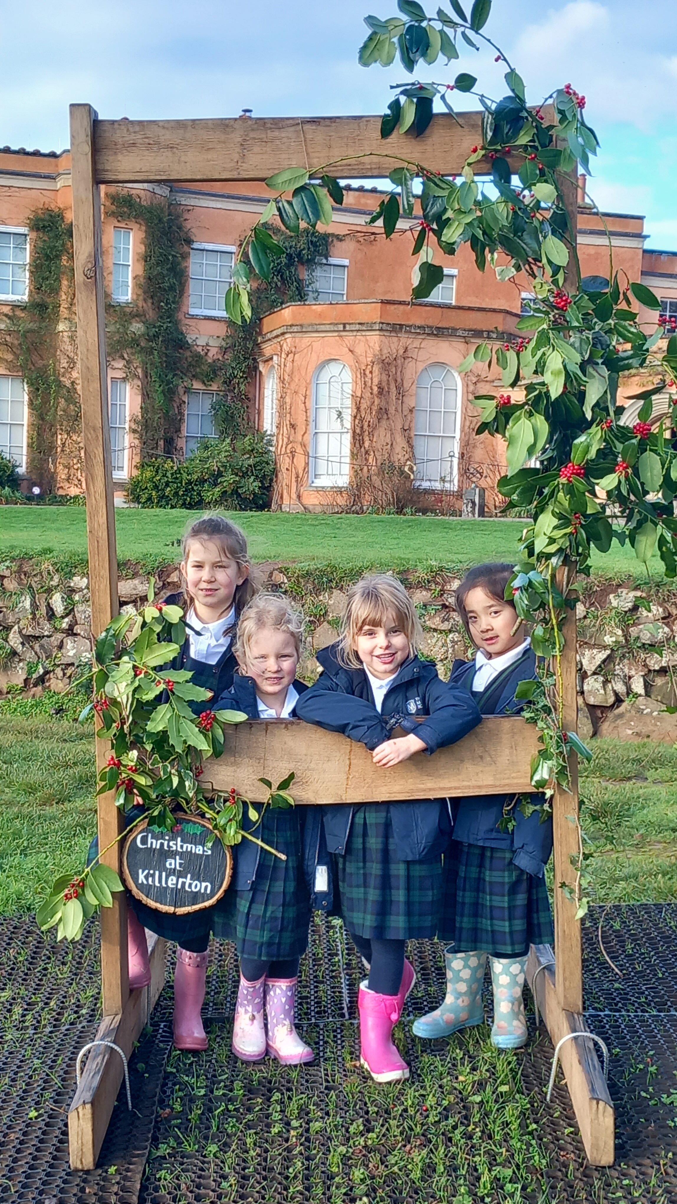 Girls posing behind a wooden sign