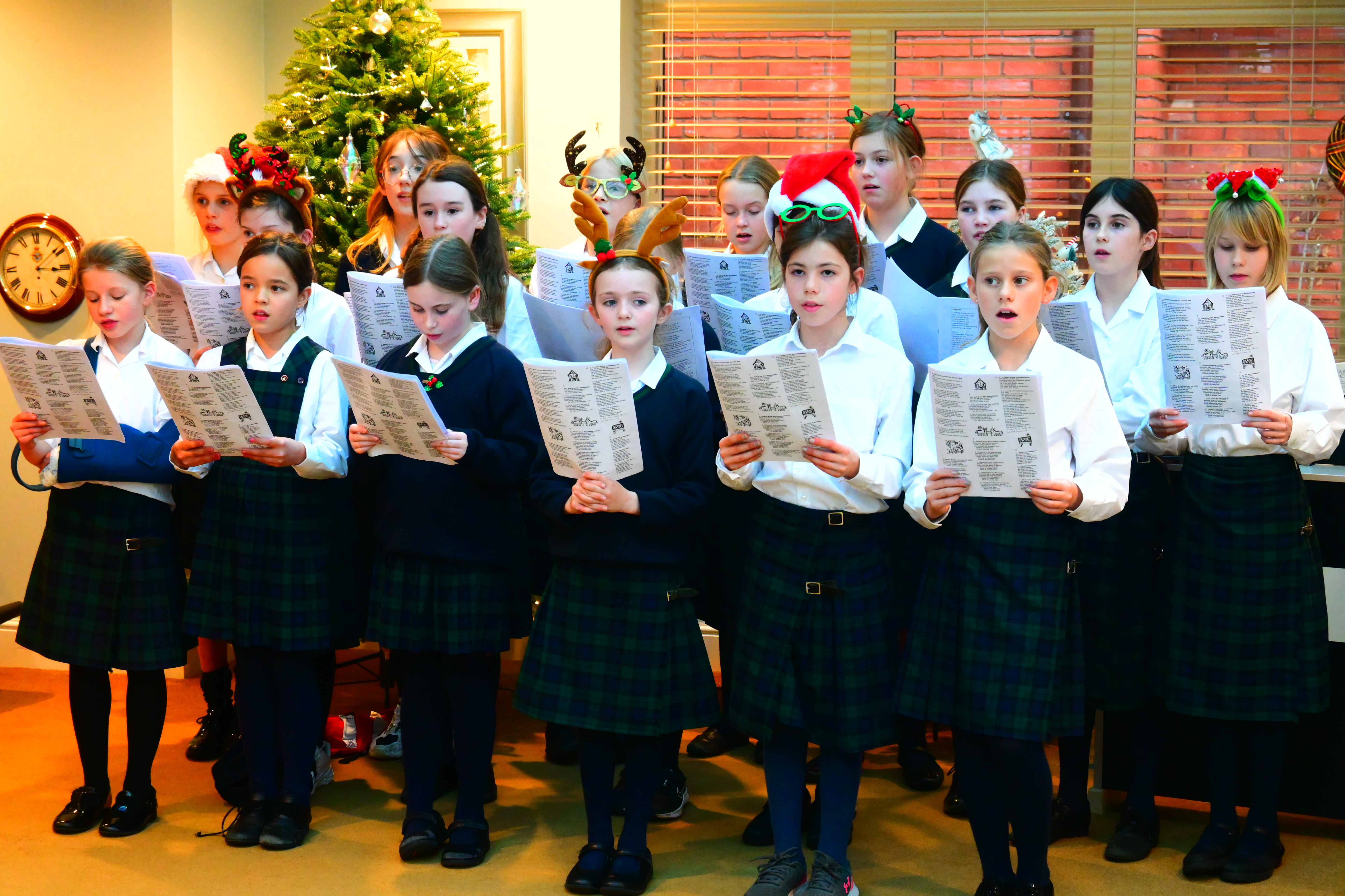 Group of girls singing with Christmas accessories